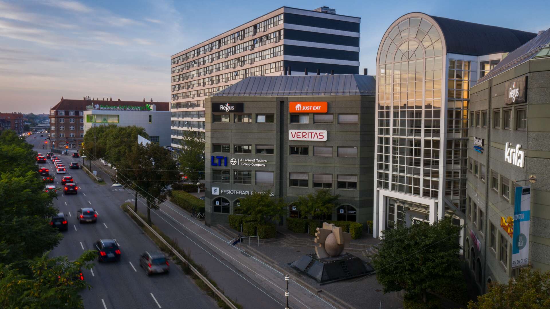 A view of an office building in Copenhagen, with a busy road in front.
